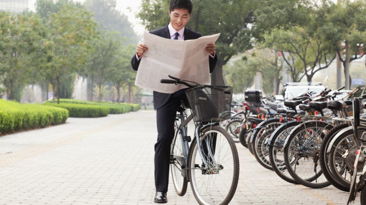 Bicyclist reading the newspaper